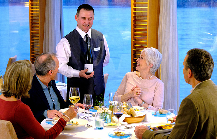 A Viking wine specialist speaking to four people at a dining table