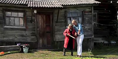 Karine Hagen outside a modest house with a small Russian woman